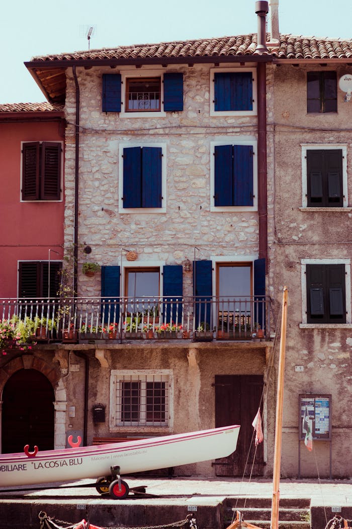 Beautiful stone houses with blue shutters by the waterfront in Malcesine, Italy.